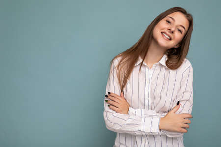 Photo of beautiful positive smiling adult woman wearing stylish clothes standing isolated on colorful background with copy space looking at cameraの写真素材