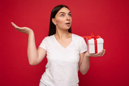 Photo shot of pretty positive surprised young brunet woman isolated over colourful background wall...