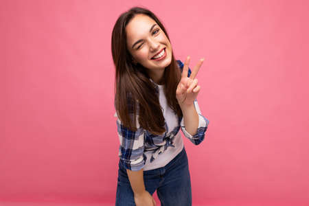 Photo shot of young positive delightful smiling pretty brunette woman with sincere emotions wearing...