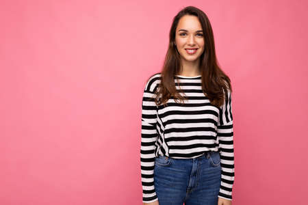 Portrait of positive cheerful fashionable woman in casual clothes isolated on pink background with copy spaceの写真素材