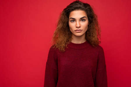 Photo of beautiful adult woman wearing stylish clothes standing isolated on colorful background with copy space looking at cameraの写真素材