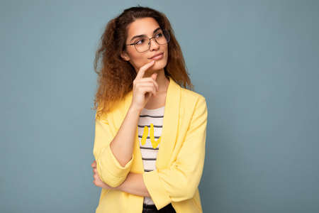 Photo of young positive dreaming thoughtful attractive brunette curly woman with sincere emotions...