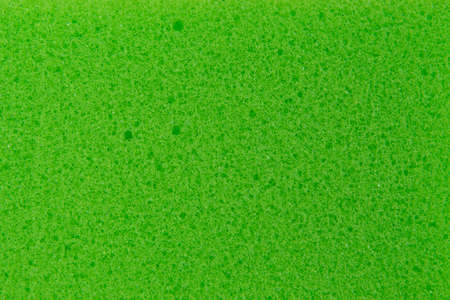 texture of green sponge for washing dishes, close-up, porous surfaceの写真素材