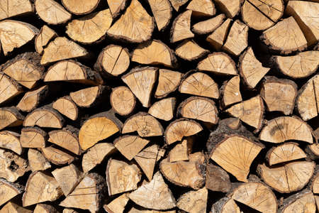Natural wooden background - closeup of chopped firewood. Firewood stacked and prepared for winter...