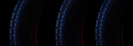 part of the tread of a winter tire on a black background close-up with blue backlight