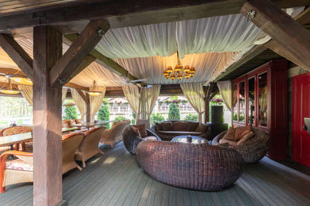 photo of a summer street cafe with wooden columns and natural wood furnitureの写真素材