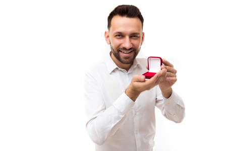 charming stylish middle-aged man charismatically stretches forward jewelry case, concept of romantic gifts and courtship, jewelry saleの写真素材
