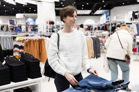 A young beautiful and attractive brunette woman with a short hair in a casual and stylish white...