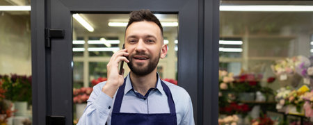 florist in the background fridge with fresh flowers takes an order by phoneの写真素材