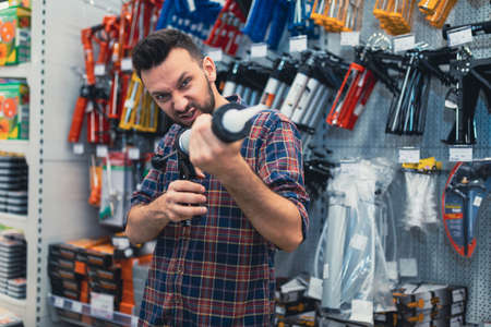 shoppers in a hardware store kidding with a construction gun for glue sealantの写真素材