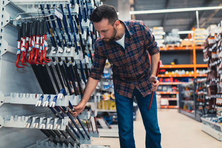 a buyer in a construction hypermarket chooses a nail pullerの写真素材