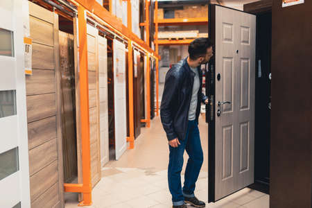 a man in a hardware store chooses new doors.の写真素材