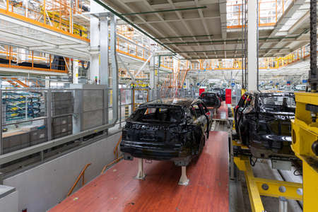 Car bodies are on assembly line. Factory for production of cars. Modern automotive industry. A car being checked before being painted in a high-tech enterpriseの写真素材