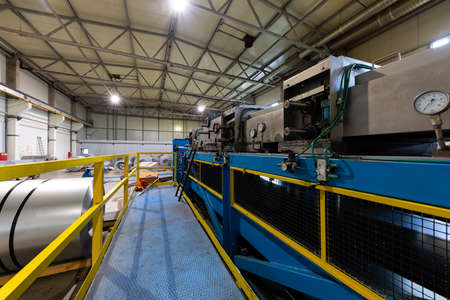 Production line of metal tile for roof. Steel forming machine in metalwork factory workshop. Metal...