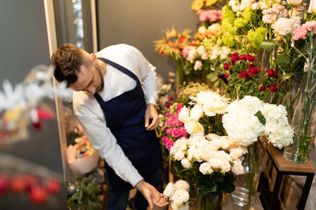 the florist in the refrigerator chooses fresh flowers for a bouquetの写真素材
