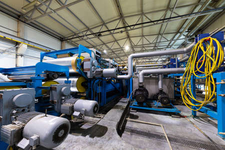 Steel roofing forming machine. Industrial machine for metal sheet roof coils cut. Process of making steel tile for roofの写真素材