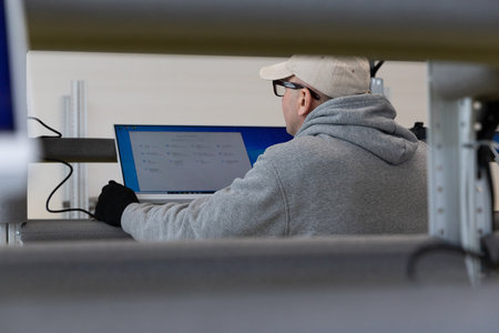 Minsk, Belarus - Jan 05, 2022: Photo of a man in a gray suit checking the computer at work. Testing....