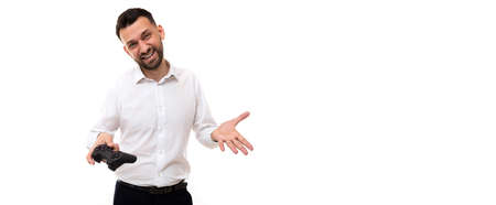 young man in a white shirt with a game joystick in his hands indignant expanding his hands gesturing
