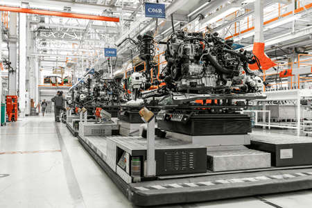 Photo of car bodies are on assembly line. Factory for production of cars. Modern automotive industry