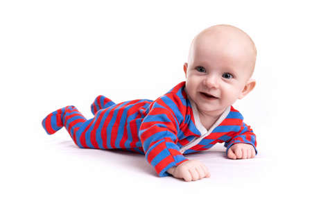 baby in a striped bodysuit on a white isolated background with a smile on his faceの写真素材