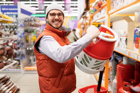 satisfied customer with a gas cylinder in his hands in a hardware store