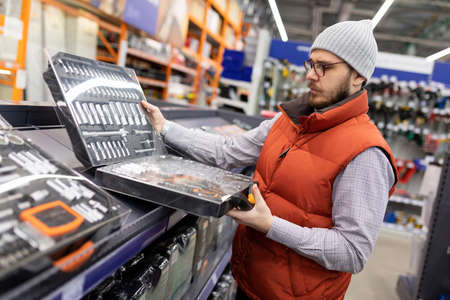 a customer in a tool building materials store chooses a new set of wrenches and socketsの写真素材