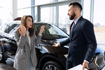 a woman defends her rights in a dealership arguing with a representative of a car dealership