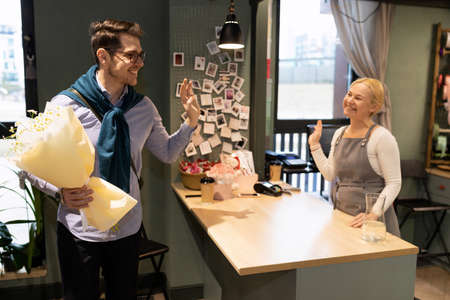 the customer thanks the seller in the flower shop for a great bouquet of fresh flowers