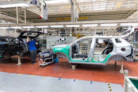 Car bodies are on assembly line. Factory for production of cars. Modern automotive industry. A car being checked before being painted in a high-tech enterpriseの写真素材