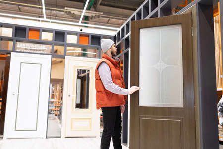 the buyer in the store chooses interior doors to his house or apartment