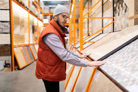 a man in a decorating store chooses flooring and wall tiles
