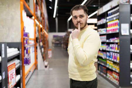 The buyer cannot decide on the color and texture of the walls when choosing paint in a hardware storeの写真素材