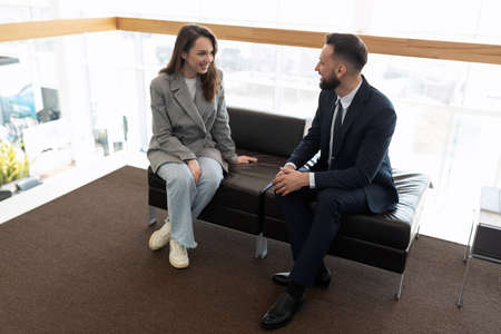 young business partners talking while sitting on the couch