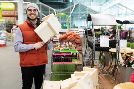happy customer with birdhouse in hands at hardware store