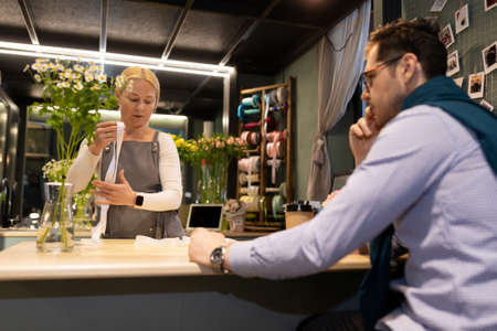 a regular customer waits with a tincture for the store employee to prepare his order