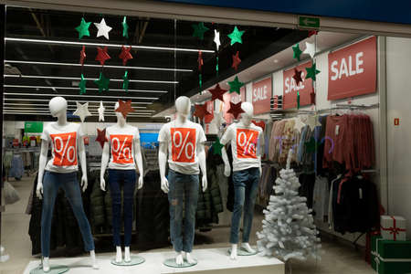 showcase of a clothing store with mannequins dressed in a t-shirt with a discount icon, Concept...