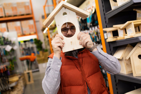 customer in garden supply store fooling around with birdhouseの写真素材