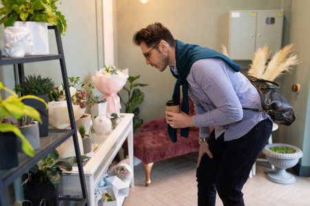 a man examines the assortment in a flower and bouquet shop before buyingの写真素材