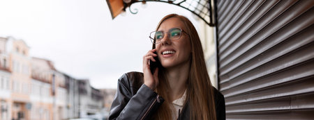 young slender girl calls on a mobile phone with a smile on her face outside the office