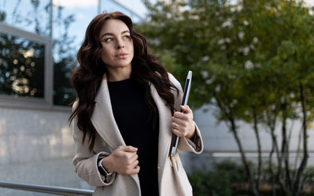 young business woman in business clothes with a laptop on the background of the office center