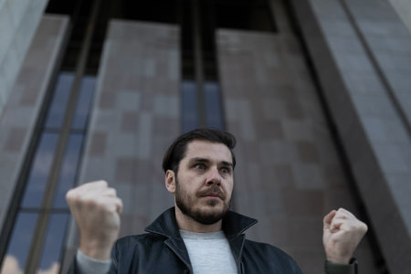 a man at the moment of a panic attack emotionally clenches his fistsの写真素材