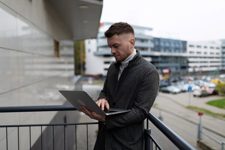 successful male businessman working on laptop outside the office