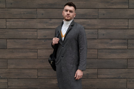 portrait of a successful young businessman in business clothes with a mobile phone in his hands in glasses for visionの写真素材