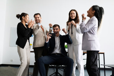 jubilant business team looking at the smartphone screenの写真素材