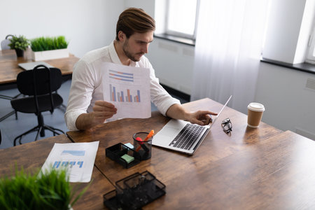 businessman studying the financial affairs of his company holding charts in his handsの写真素材