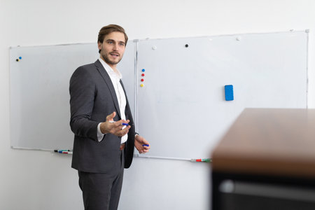 a man financial analyst discusses the affairs of the company standing near the blackboardの写真素材
