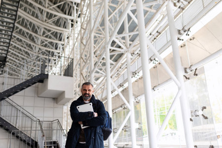 portrait of a european businessman with papers in his hands in the lobby of the building