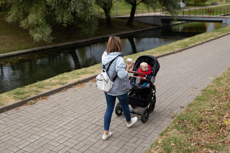 happy young mother walking with her little son in the parkの写真素材