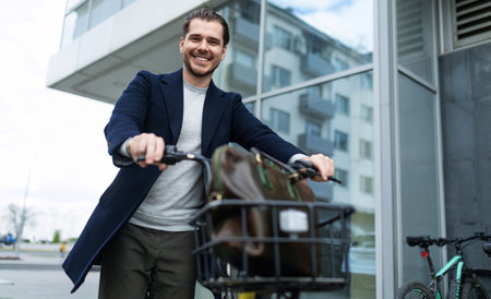 joyful young architect on a rental bike in the streetの写真素材