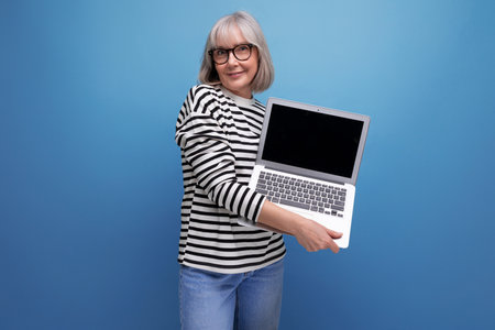 modern woman 60s business holding pc with advertising mockup on bright studio backgroundの写真素材